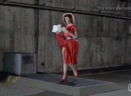المرأة ذات الشعر الأحمر ترتدي أحذية ذات أعقاب عالية بينما تستعد للاستمتاع.
